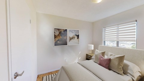 A bedroom with a large bed and a picture on the wall.